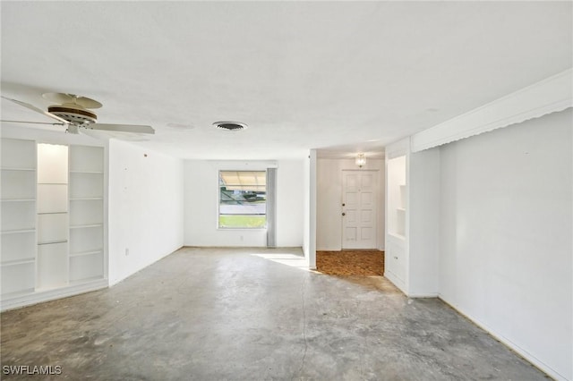 unfurnished room featuring ceiling fan, built in shelves, and concrete floors