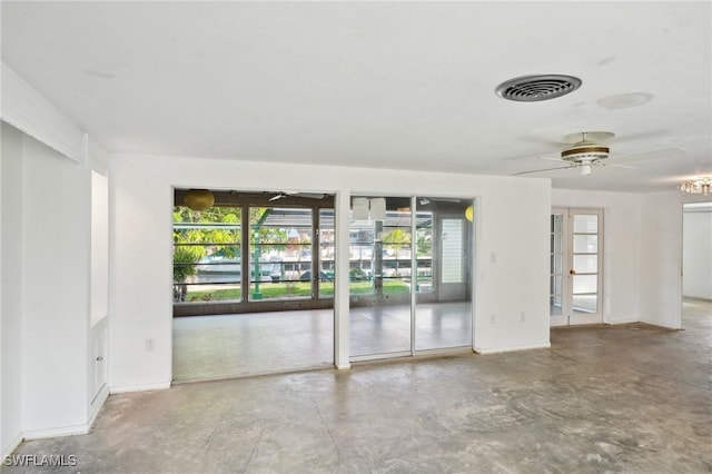 unfurnished room with ceiling fan and concrete floors