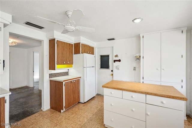 kitchen featuring ceiling fan, white cabinets, and white refrigerator