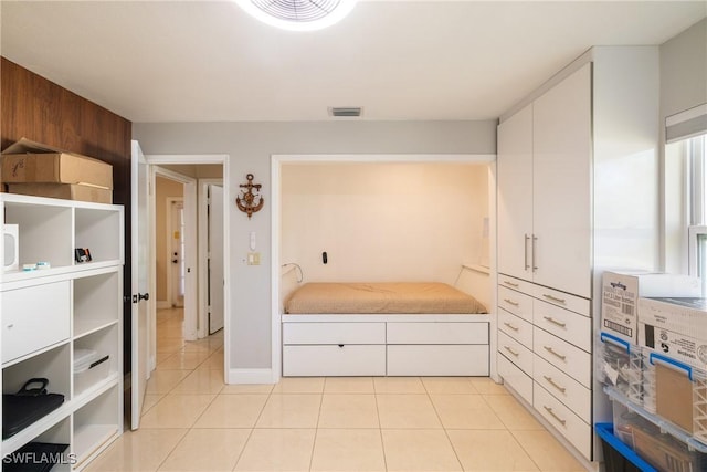 bedroom featuring wooden walls and light tile patterned flooring