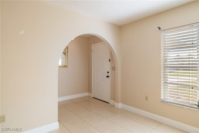 interior space featuring light tile patterned floors and a textured ceiling