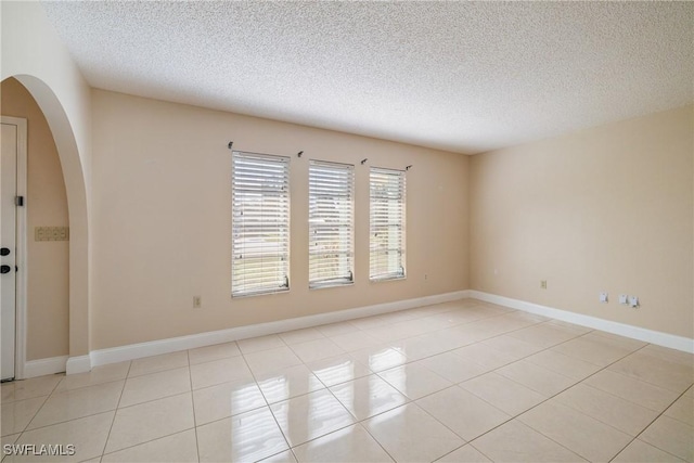 empty room featuring light tile patterned floors and a textured ceiling