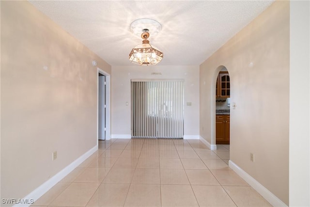 interior space featuring light tile patterned flooring, a chandelier, and a textured ceiling