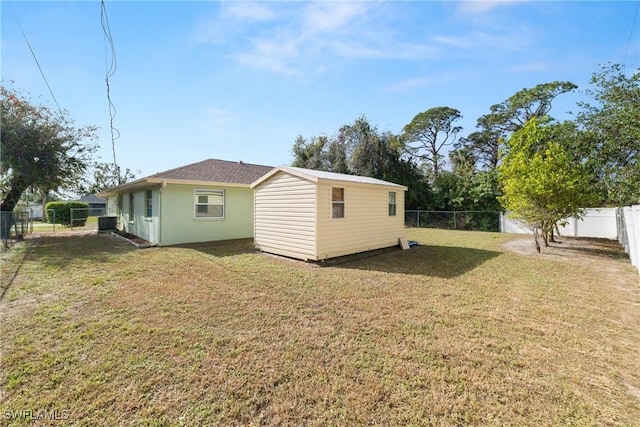 back of house featuring a lawn and cooling unit