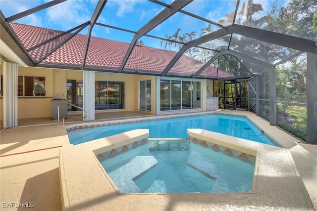 view of pool featuring an in ground hot tub, a patio area, and a lanai