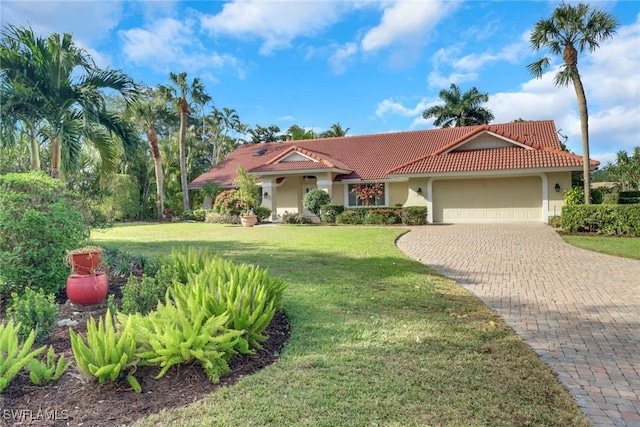 mediterranean / spanish house with a garage and a front lawn