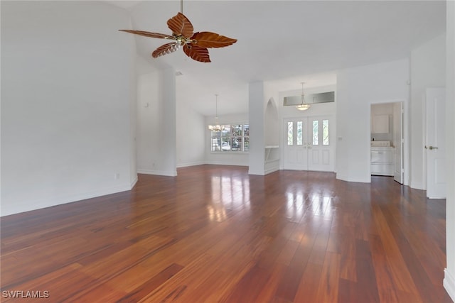 unfurnished living room with dark wood-type flooring and ceiling fan with notable chandelier