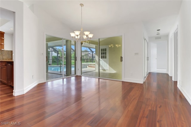 unfurnished dining area featuring a chandelier and dark hardwood / wood-style floors