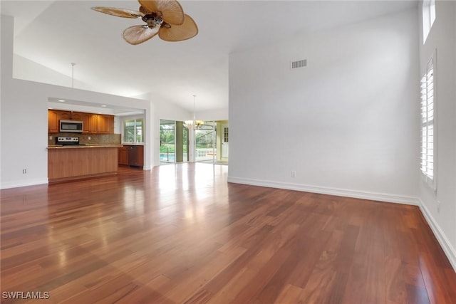 unfurnished living room featuring high vaulted ceiling, dark wood-type flooring, and ceiling fan with notable chandelier