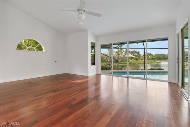 spare room with ceiling fan, dark hardwood / wood-style floors, a water view, and high vaulted ceiling