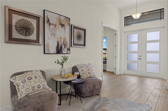 sitting room featuring light wood-type flooring and french doors