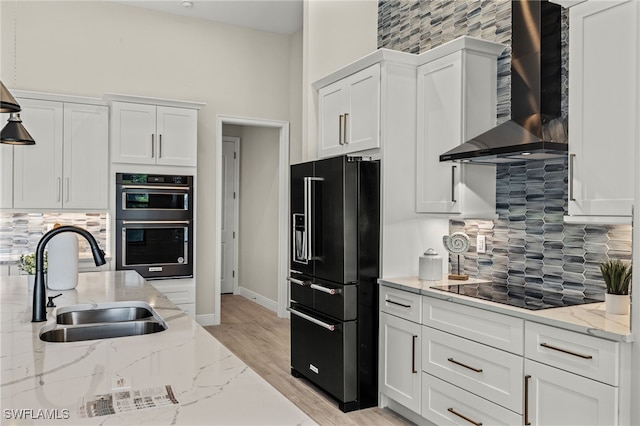 kitchen featuring white cabinets, sink, wall chimney exhaust hood, and black appliances