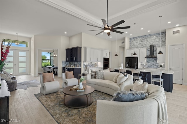 living room featuring ceiling fan, light hardwood / wood-style flooring, and french doors