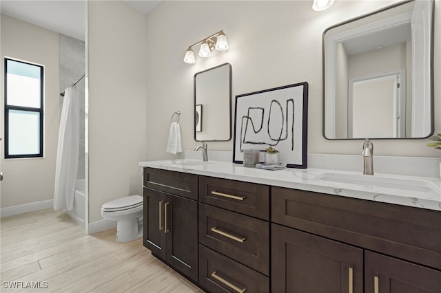 full bathroom featuring wood-type flooring, vanity, shower / bath combination with curtain, and toilet