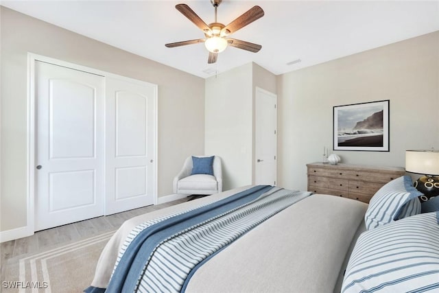 bedroom featuring light hardwood / wood-style flooring, a closet, and ceiling fan