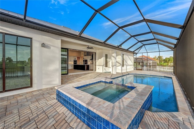 view of swimming pool featuring ceiling fan, a lanai, an in ground hot tub, and a patio