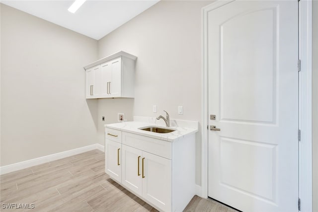 clothes washing area with washer hookup, electric dryer hookup, cabinets, and sink