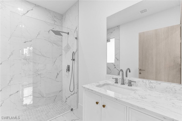 bathroom featuring a tile shower and vanity