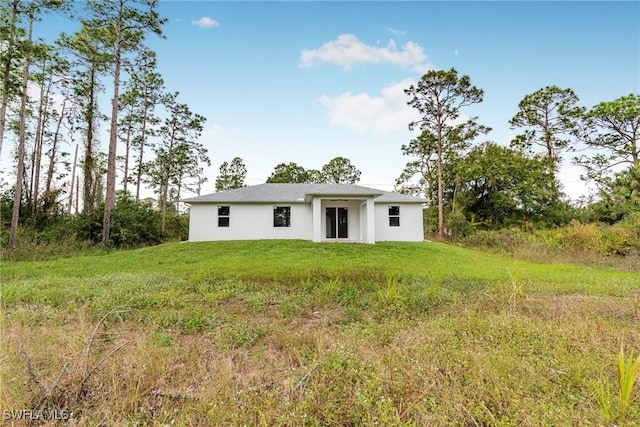 rear view of property with a yard