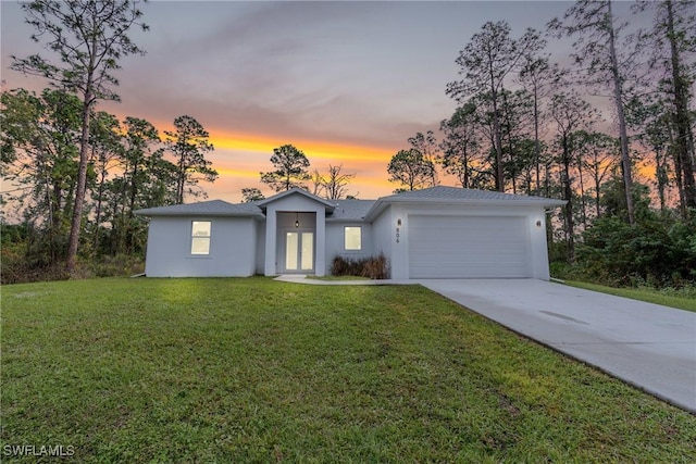 single story home with a garage and a lawn