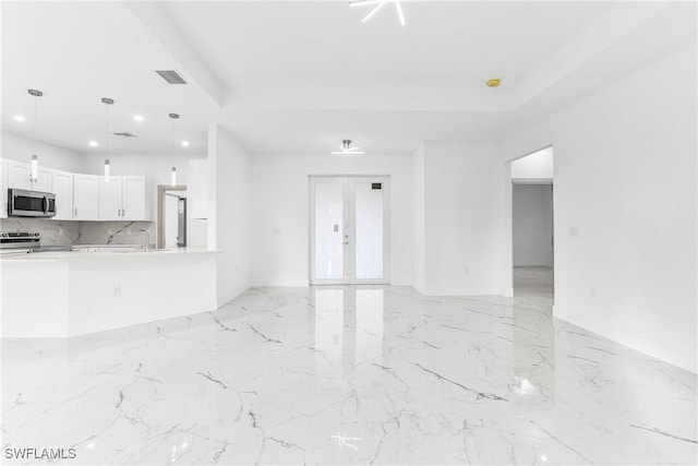 unfurnished living room with a raised ceiling