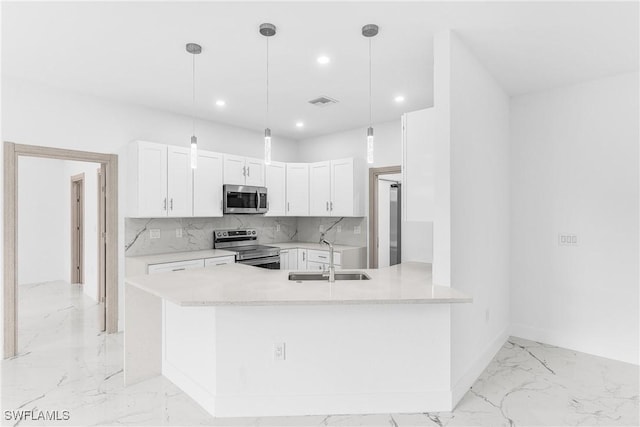 kitchen with pendant lighting, sink, white cabinetry, kitchen peninsula, and stainless steel appliances