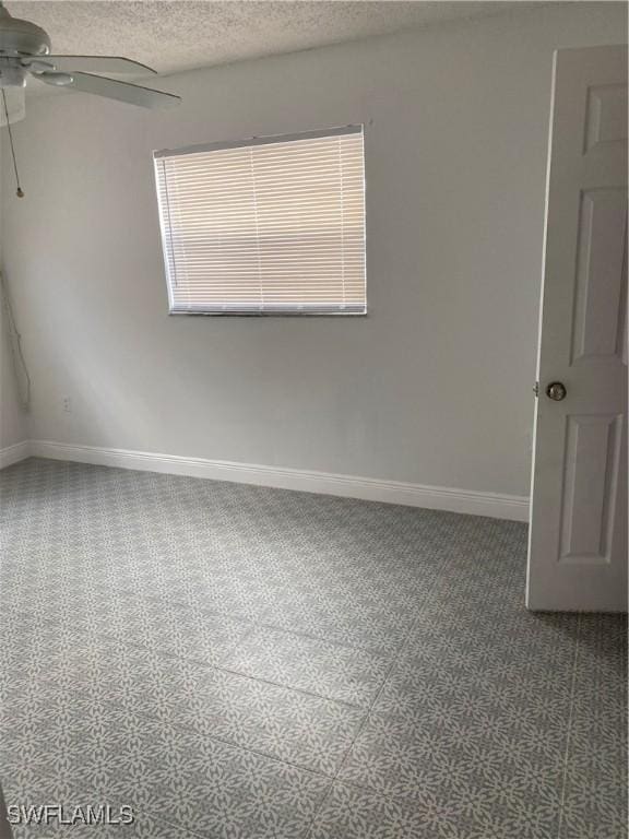 empty room featuring carpet, ceiling fan, a textured ceiling, and baseboards