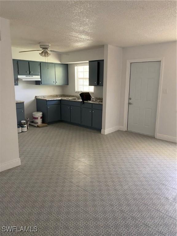 kitchen with ceiling fan and a textured ceiling