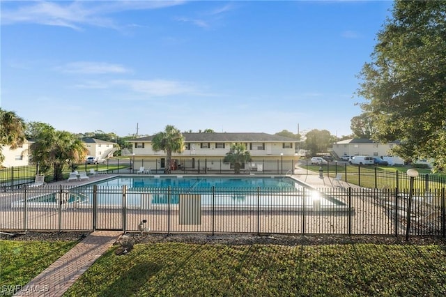 community pool featuring a patio area, fence, and a yard