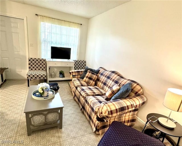 living room with carpet, a textured ceiling, and baseboards