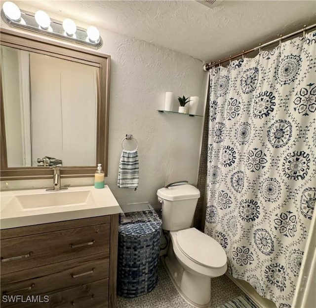 bathroom with a textured wall, toilet, a textured ceiling, vanity, and a shower with curtain