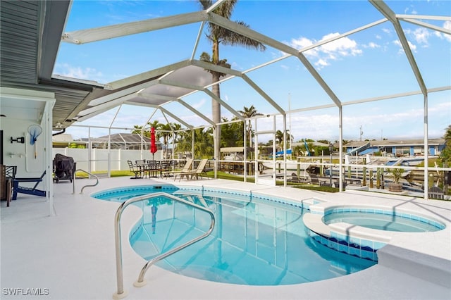 view of pool featuring a patio area, a lanai, and an in ground hot tub