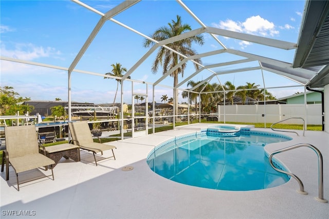 view of pool featuring glass enclosure, a patio area, and an in ground hot tub