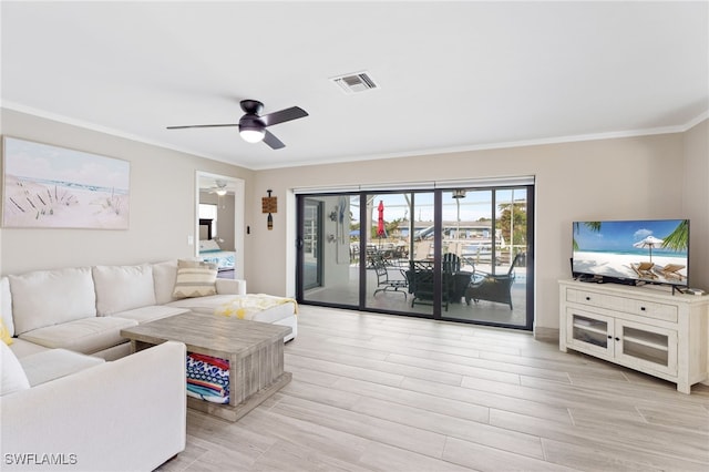 living room featuring ceiling fan, crown molding, and light hardwood / wood-style flooring