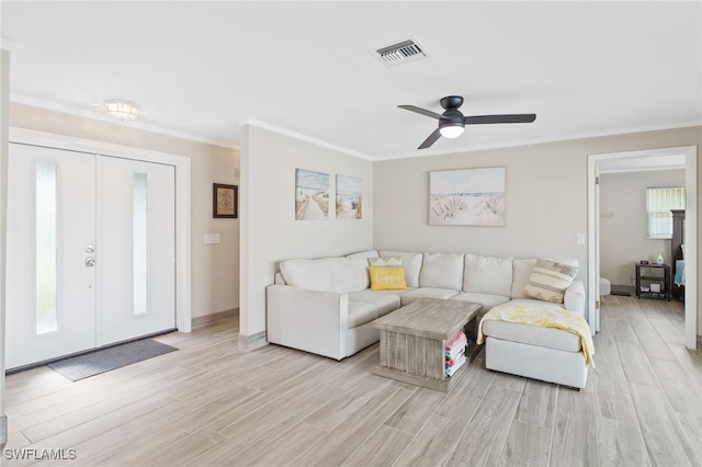 living room featuring light hardwood / wood-style flooring, ceiling fan, and crown molding