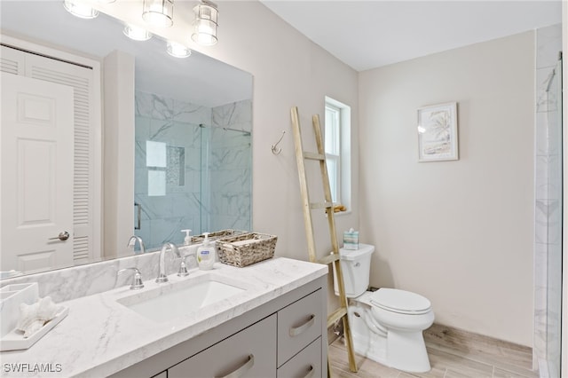 bathroom with hardwood / wood-style floors, vanity, toilet, and a shower with shower door