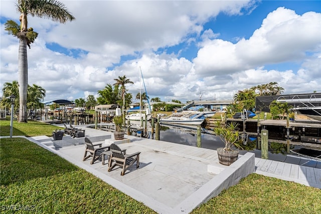 dock area with a lawn and a water view