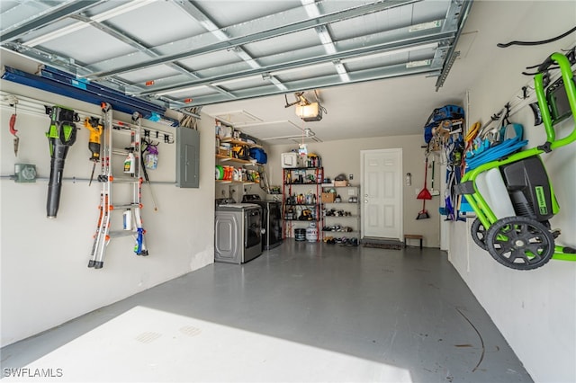 garage featuring electric panel, washer and clothes dryer, and a garage door opener