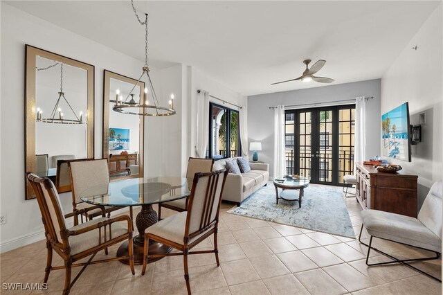 dining area with french doors, ceiling fan with notable chandelier, and light tile patterned floors