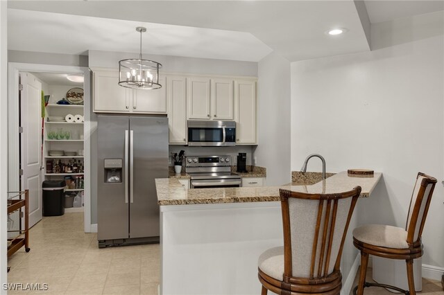 kitchen with a kitchen bar, stainless steel appliances, and kitchen peninsula