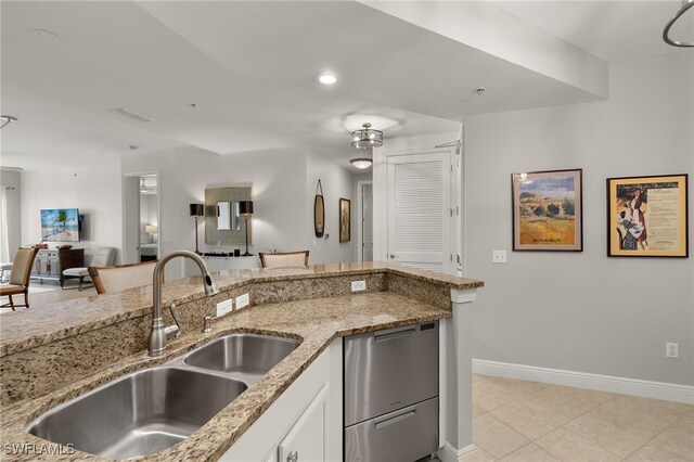 kitchen featuring dishwasher, white cabinets, sink, light tile patterned flooring, and light stone counters