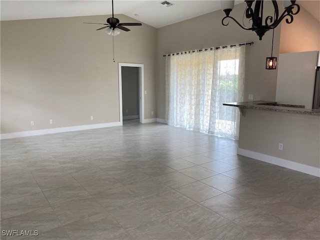 tiled spare room with ceiling fan with notable chandelier and high vaulted ceiling