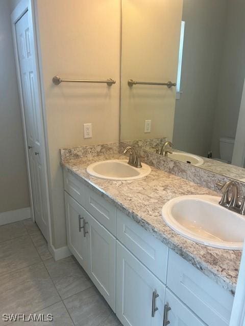 bathroom featuring tile patterned floors, vanity, and toilet