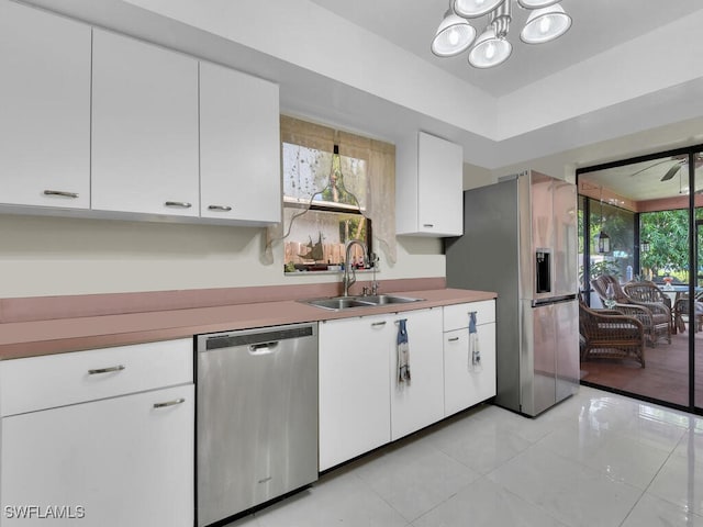 kitchen featuring stainless steel appliances, white cabinetry, and sink