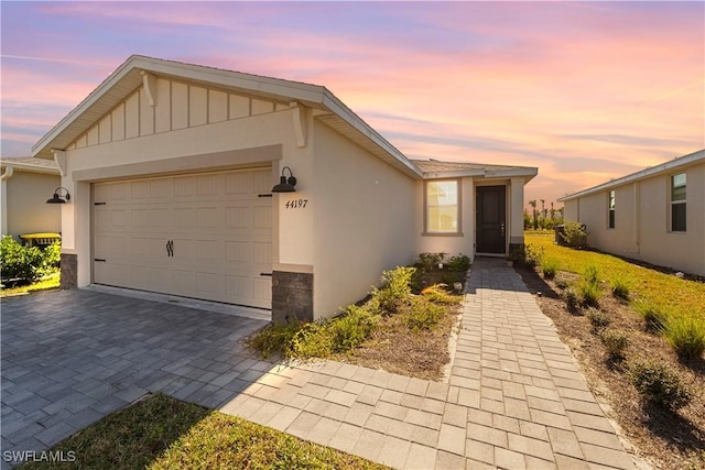 view of front of house featuring a garage, decorative driveway, and stucco siding