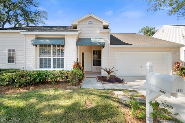 view of front of property featuring a front yard and a garage