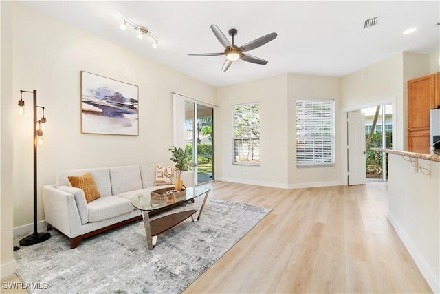 living room featuring light hardwood / wood-style flooring and ceiling fan