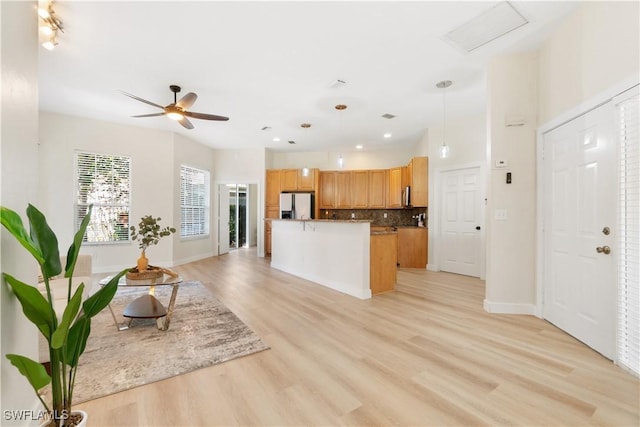 kitchen with ceiling fan, a center island, white fridge, light hardwood / wood-style floors, and decorative light fixtures