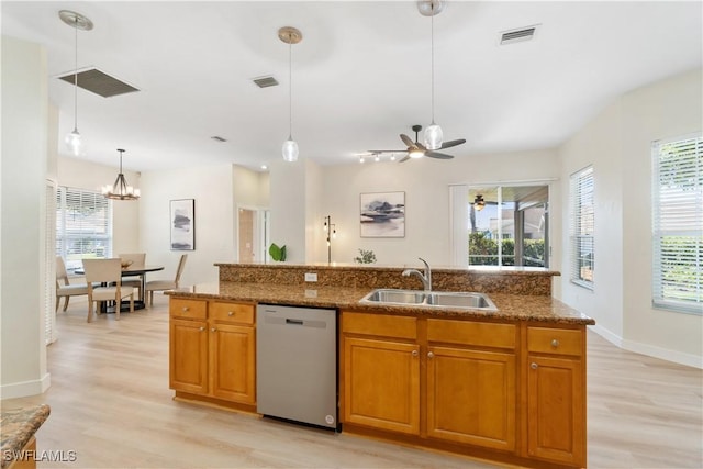 kitchen with pendant lighting, dishwasher, ceiling fan with notable chandelier, sink, and light hardwood / wood-style flooring