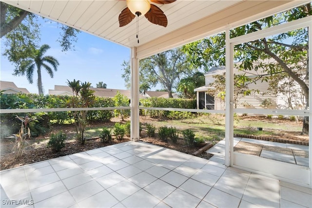 unfurnished sunroom featuring ceiling fan